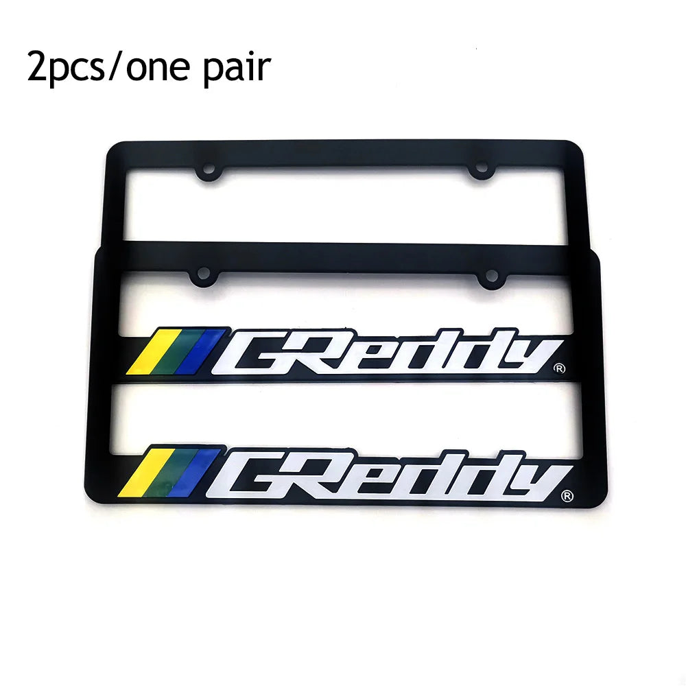 A pair of black racing style license plate frames with the Greddy logo.