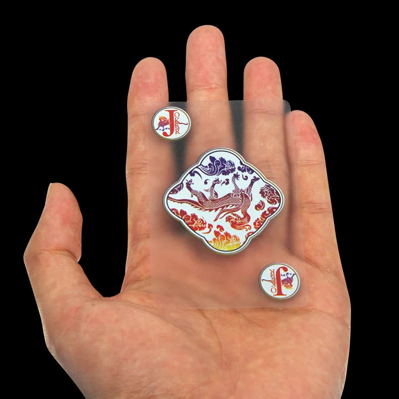 Une main tient plusieurs cartes à jouer en PVC transparent et imperméable, dont un Joker et une carte de figure.