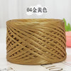 A spool of metallic gold flat ribbon yarn for crochet and knitting