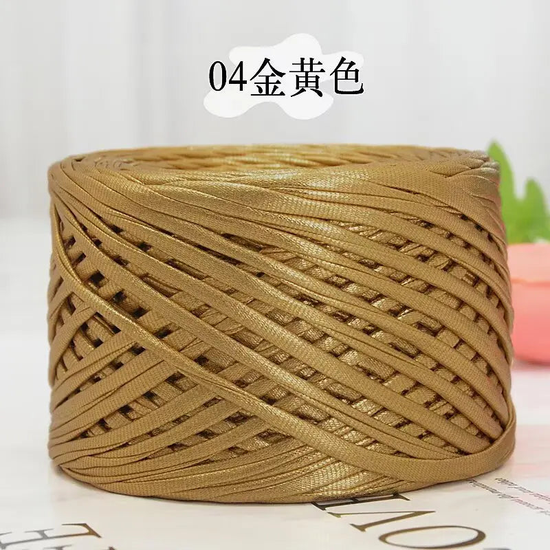 A spool of metallic gold flat ribbon yarn for crochet and knitting