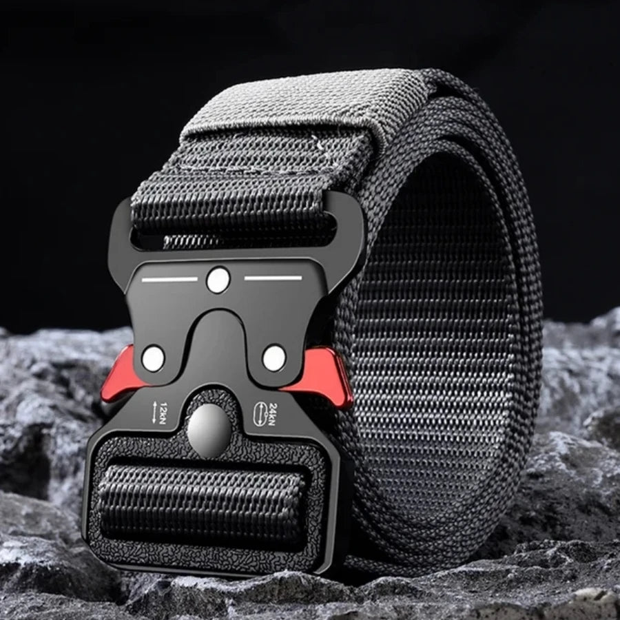 A close-up of a black tactical nylon belt with a secure metal buckle resting on a dark, textured surface.
