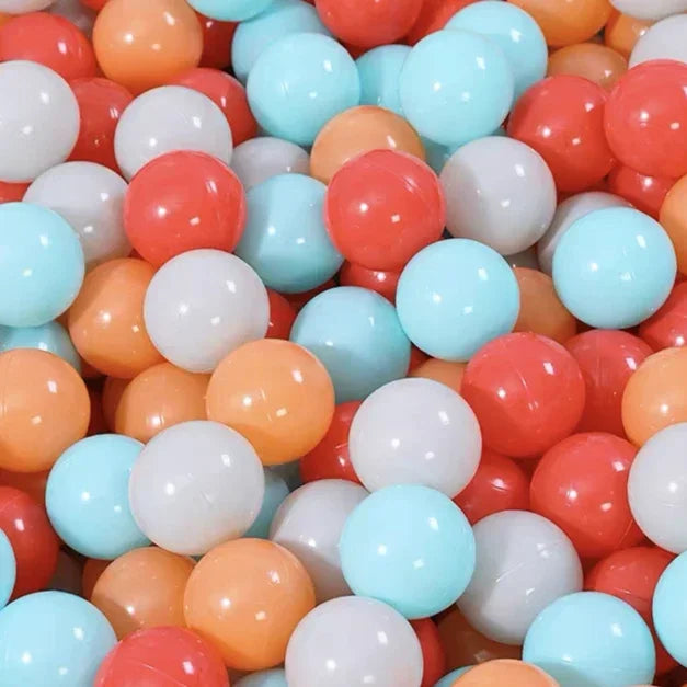 A close-up view of a large pack of colorful plastic ball pit balls in shades of orange, pink, white, and light blue.