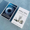 A box of the Spill Tea Oracle Card Deck with a title card for Karmic Lesson