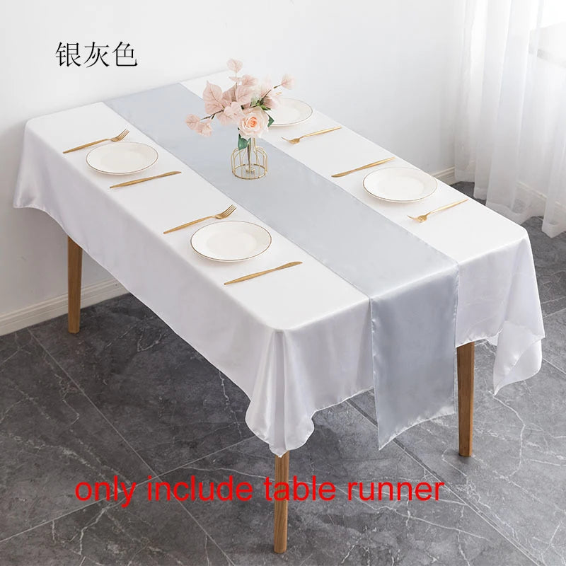 Elegant silver satin table runner set with plates and cutlery for a formal event