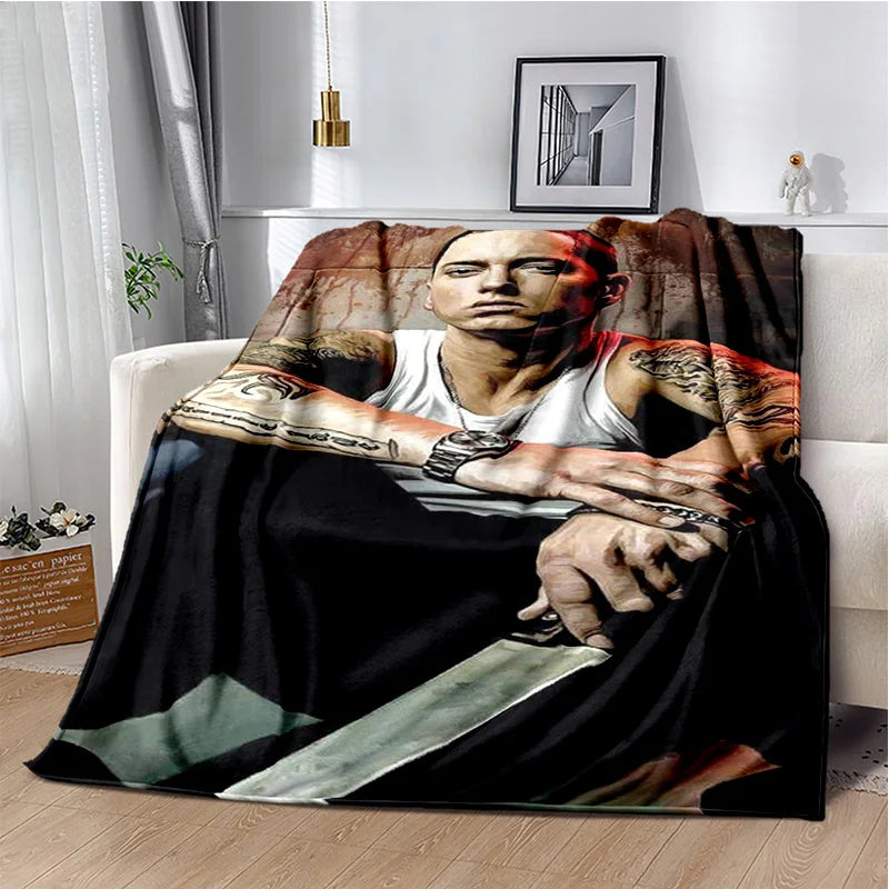 A dark throw blanket featuring a portrait of Eminem and 2Pac with tattoos and a knife motif.