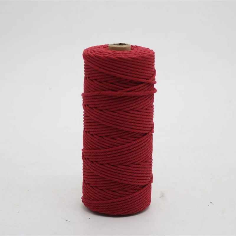 A spool of red macrame cord, 3mm/4mm thickness, used for crafting.