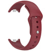 A close-up view of a red silicone replacement strap for a fitness tracker, showing the buckle and strap design.
