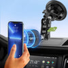 A hand is attaching a magnetic car phone mount to a vehicle interior using a metal plate ring.