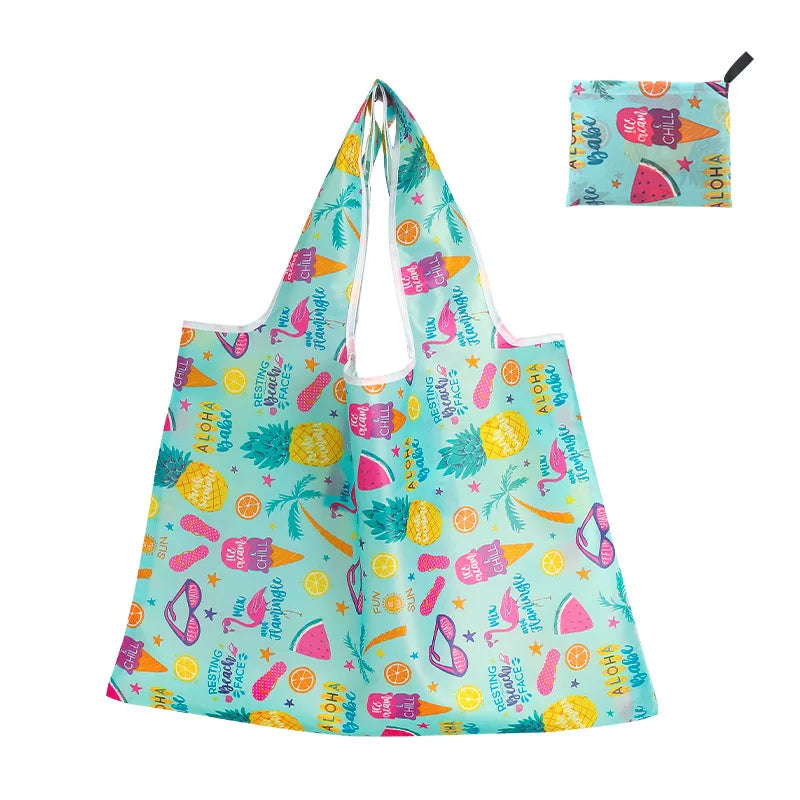 A light blue reusable shopping tote bag featuring tropical fruit and leaf patterns.
