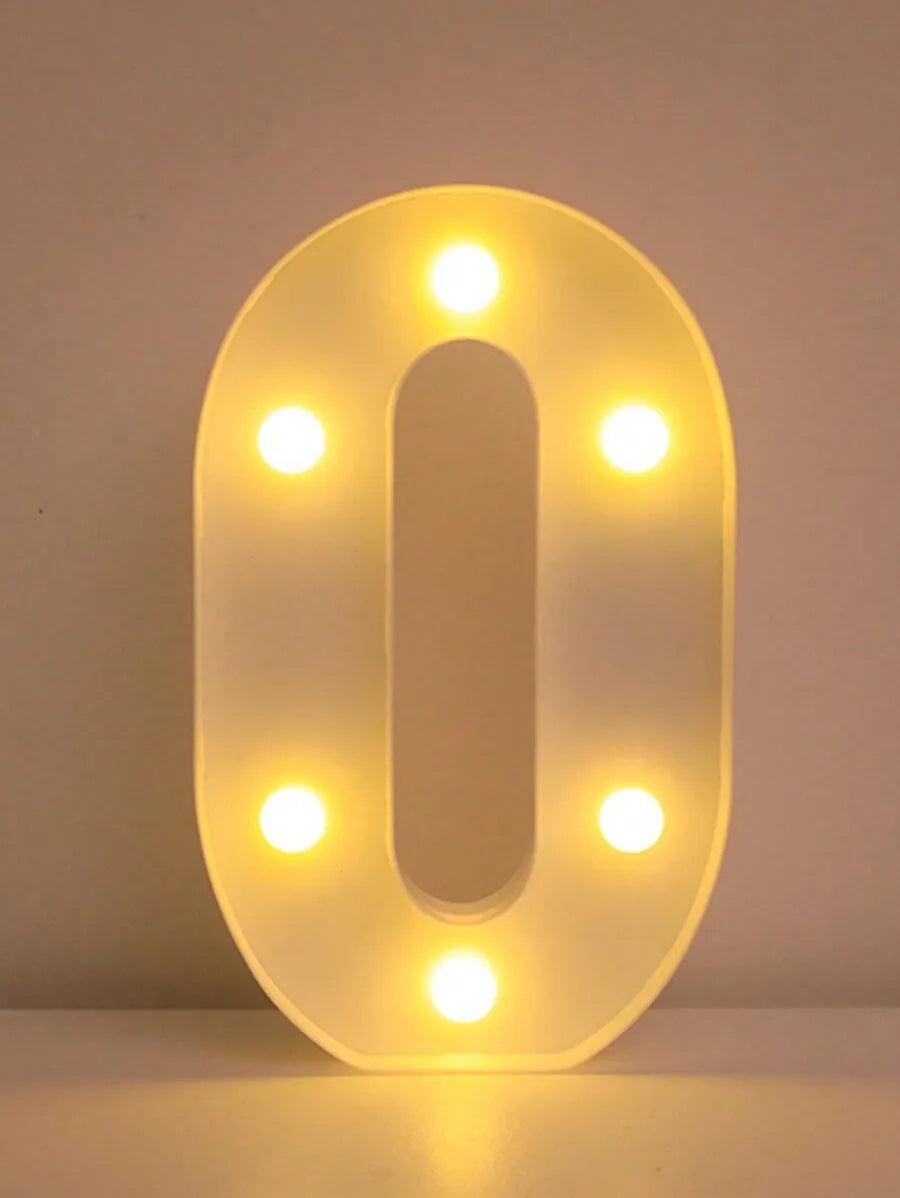 A glowing, oval-shaped LED letter night light shaped like the number zero, illuminating the surrounding area.
