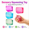 A set of four colorful sensory squeezing toys or stress cubes in pink, blue, and green, shown next to a hand.