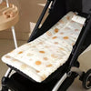 A padded white and gold patterned seat cushion is shown installed in a black baby stroller seat.