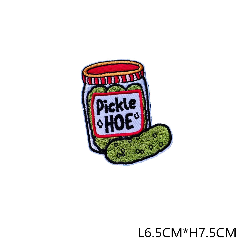 An embroidered letter patch featuring a jar labeled Pickle HOE with green pickles.