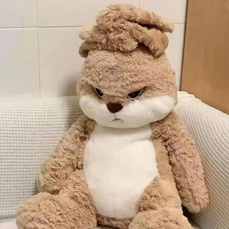 A fluffy brown rabbit plush toy with white accents sitting on a light-colored sofa.