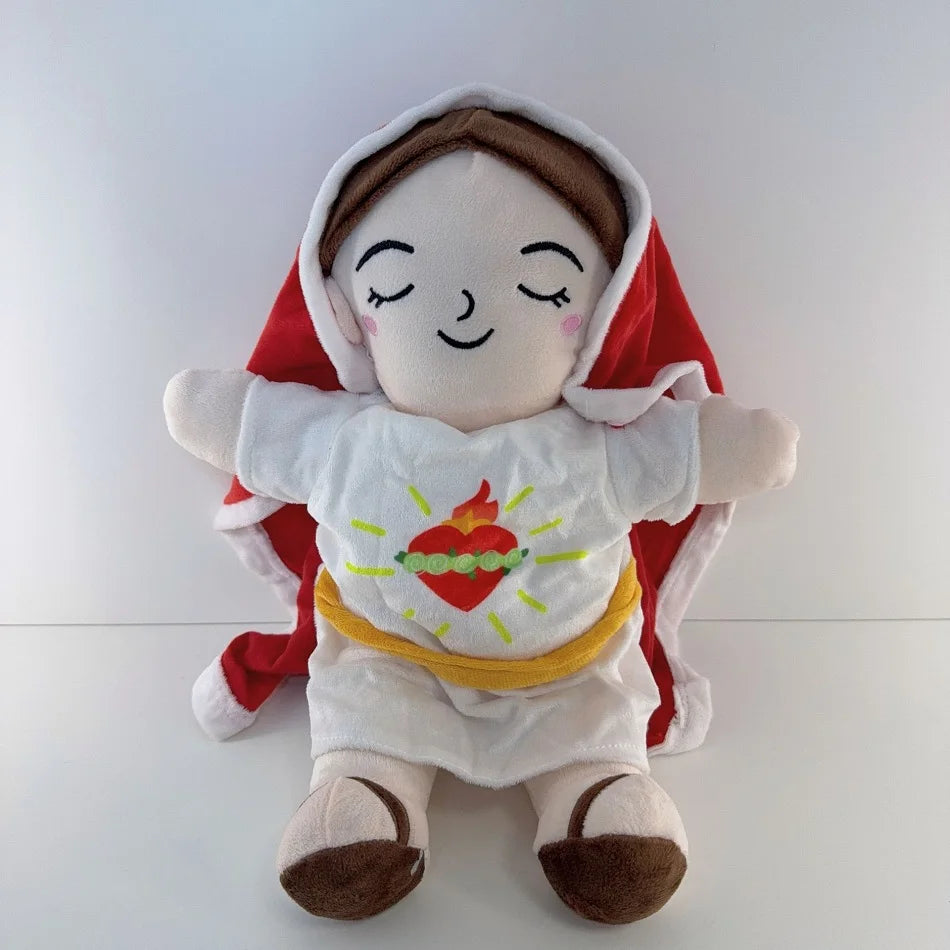A soft white plush of Jesus wearing a red cape and yellow garment with closed eyes.