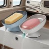 A white soap dish with a pink soap bar and a clear draining tray is shown on a counter.