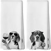 A pair of soft white kitchen towels featuring a dog print, used for cleaning.