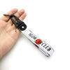 A black steel clip keychain featuring text on a white strap for a JDM style anime girl theme