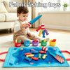 A toddler is playing with a fabric fishing toy set featuring colorful fish and fishing rods on a blue mat.