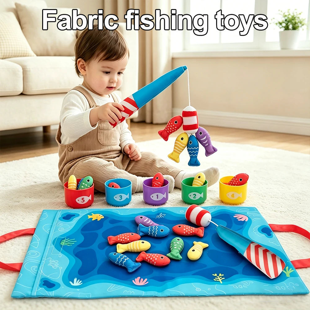 A toddler is playing with a fabric fishing toy set featuring colorful fish and fishing rods on a blue mat.