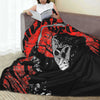 A black and red horror movie themed fleece throw blanket draped over a person reading a book.