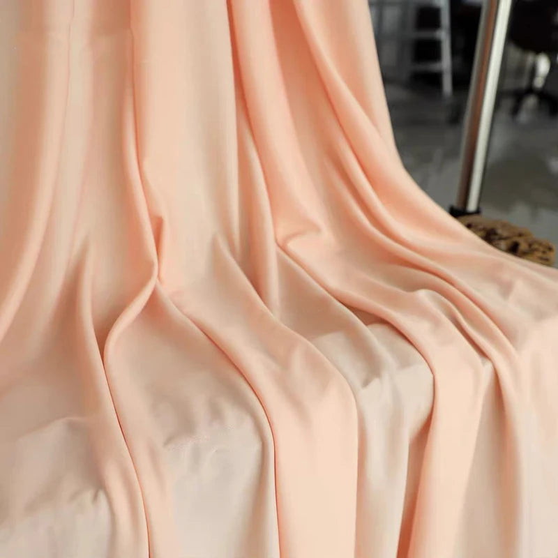 Soft peach or blush colored stretch jersey fabric draped in flowing folds