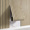 A close-up of a beige wood grid peel-and-stick wall panel installed on a vertical wooden slat background.