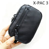 A hand holds a black X-PAC 3 utility pouch featuring a zipper and a toggle closure.