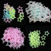 A collection of glow-in-the-dark 3D star wall stickers in pink, blue, and green shades.