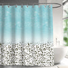 A light blue and teal abstract geometric shower curtain with a leopard print border hanging on a rod.