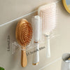 Wall-mounted acrylic organizer holding wooden and white hairbrushes and combs.