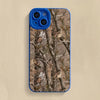 A blue silicone phone case featuring a forest camouflage pattern of tree branches and leaves.