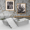 Stacks of white marble self-adhesive wall stickers displayed against a gray tiled wall.