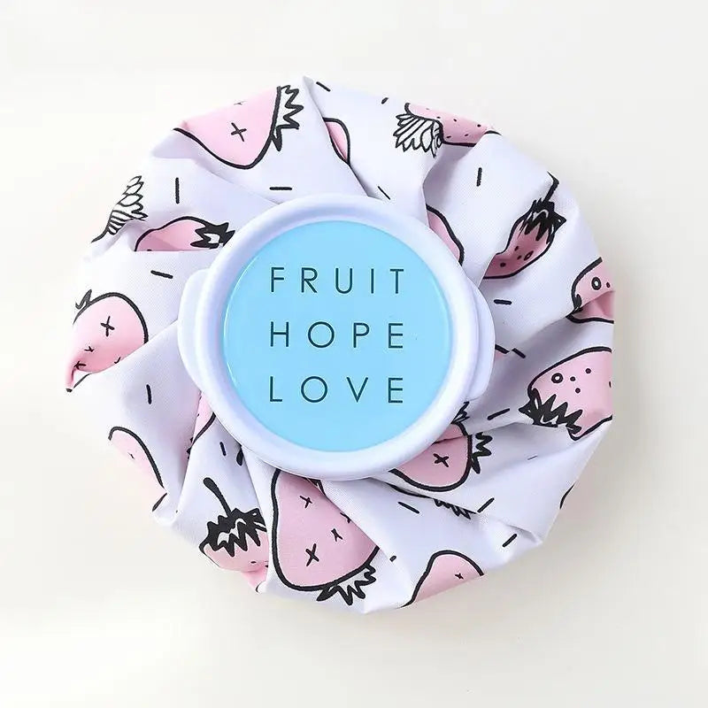 A reusable multi-use ice and heat therapy pack made of white fabric with pink fruit designs.