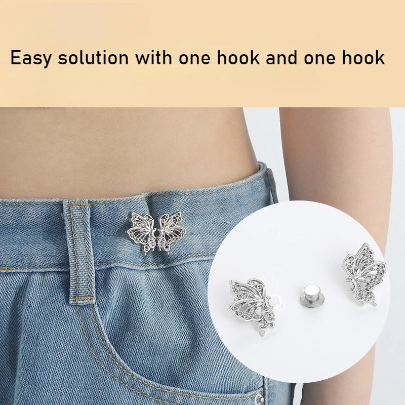 A close-up of a silver butterfly hook being used to adjust the waist of a denim jean skirt.