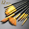 A set of twelve nylon bristle flat paint brushes with gold ferrules laid out on a dark surface.