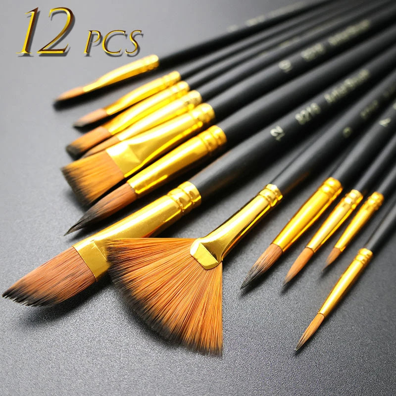 A set of twelve nylon bristle flat paint brushes with gold ferrules laid out on a dark surface.