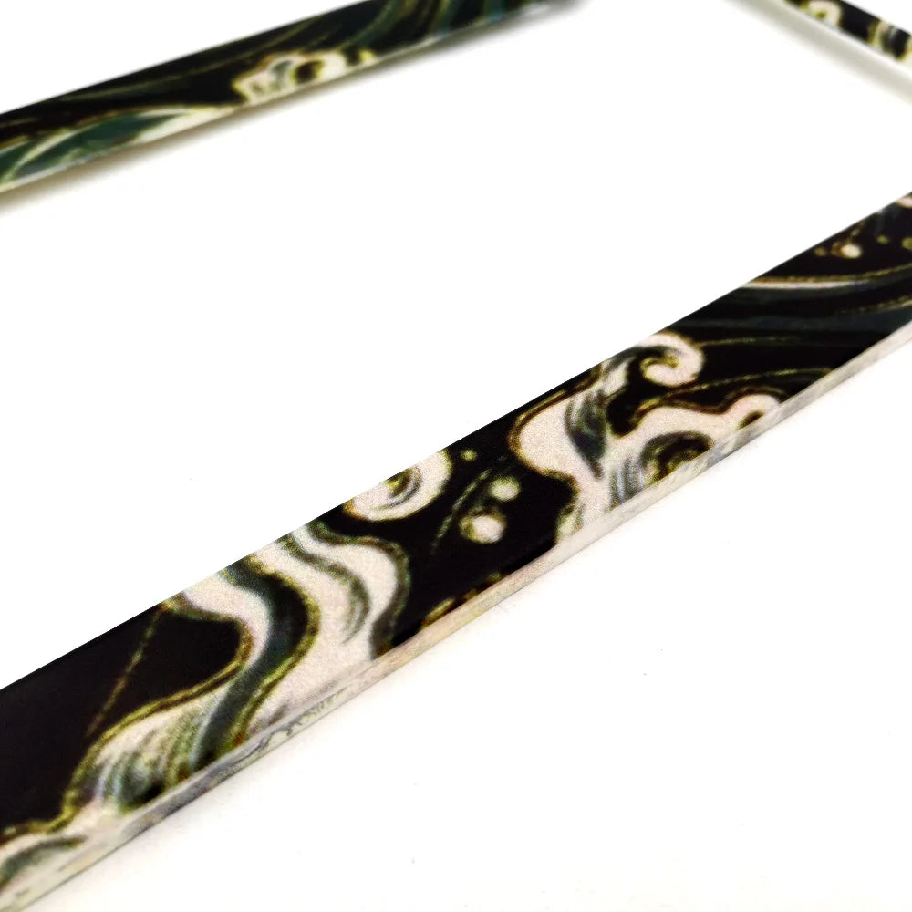 A pair of racing style license plate frames featuring a black and white marbled pattern with a JDM aesthetic.