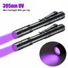 A black mini flashlight with a pen clip emitting purple UV light.