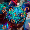 A close-up of a translucent blue and green polyhedral die resting on a reflective surface.
