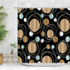 Geometric black and white fabric shower curtain featuring gold and light blue circular patterns.