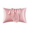 Funda de almohada de satén de seda rosa con detalle de tela drapeada.