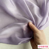 Close-up of light purple silk chiffon fabric being held and draped
