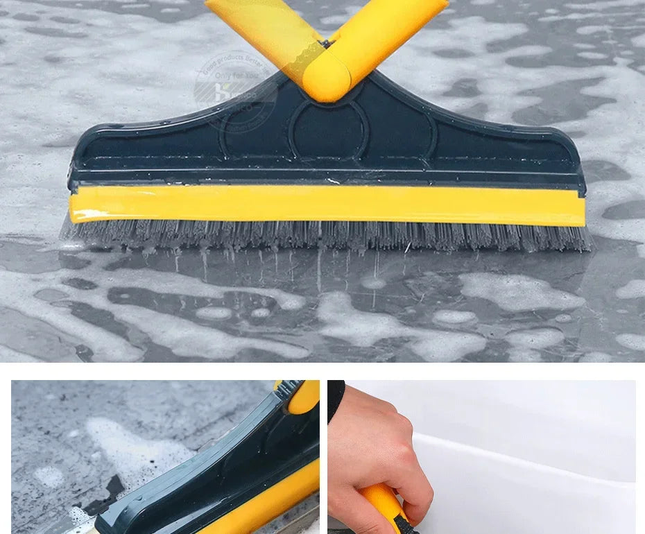 A dark blue and yellow 2-in-1 floor scrub brush with a squeegee is shown cleaning a wet, mottled surface.
