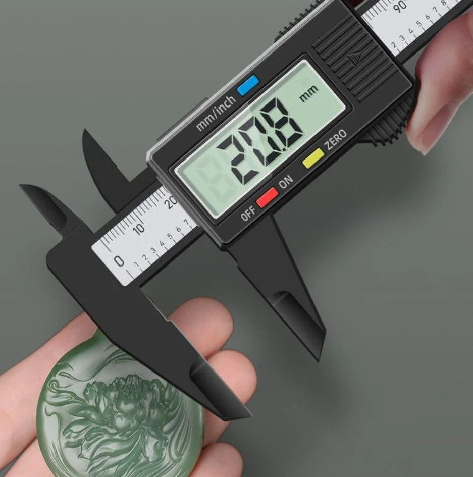 A hand holds a digital caliper measuring a green leaf, displaying a measurement of 20.8 mm.