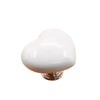 White heart-shaped toilet flush button with a nail protector.
