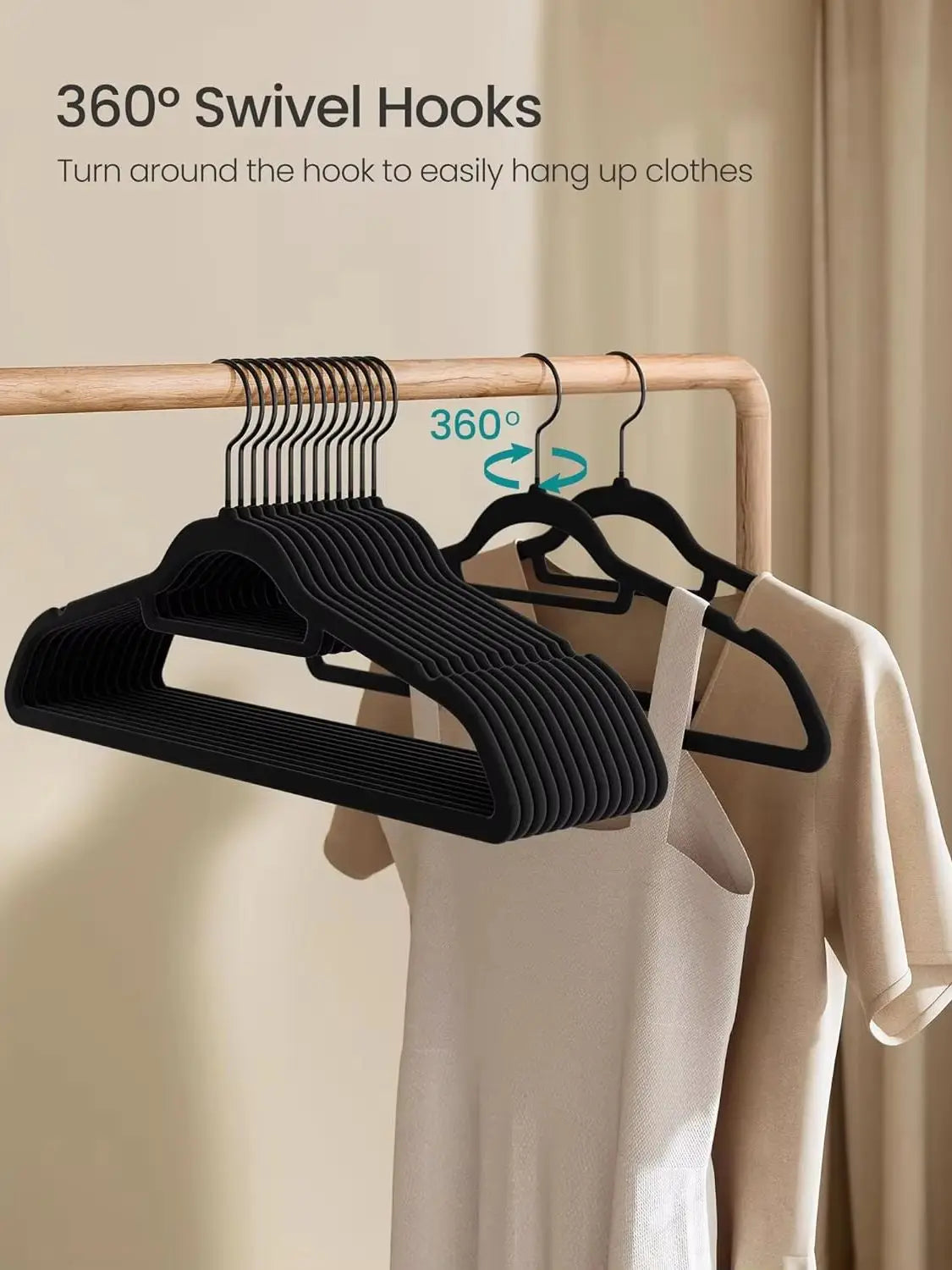 Black premium velvet hangers with 360° swivel hooks hanging on a wooden rod.