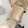 A beige stroller cushion with a pattern of small brown hearts is shown inside a stroller frame.