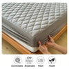 A gray fitted mattress protector is shown being placed onto a wooden bed frame, highlighting its comfortable, breathable, was