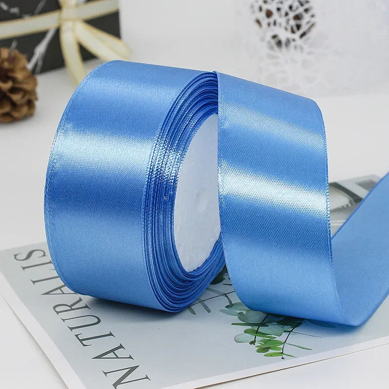 A roll of smooth, light blue satin ribbon used for gift wrapping or crafts.